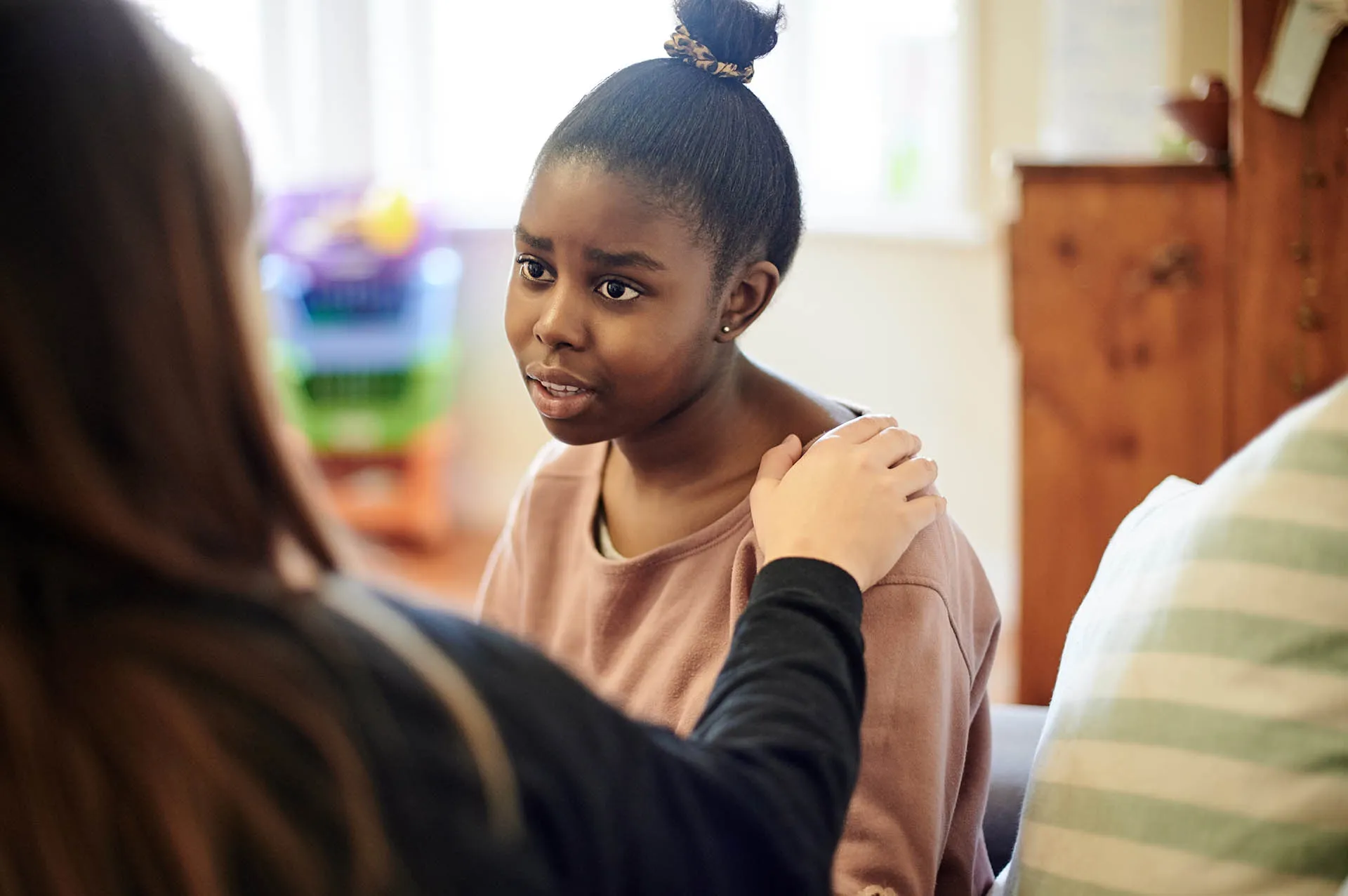 Scorpion's partnership with FAMSA providing social support – young girl talking to a therapist putting a supportive hand on her shoulder.